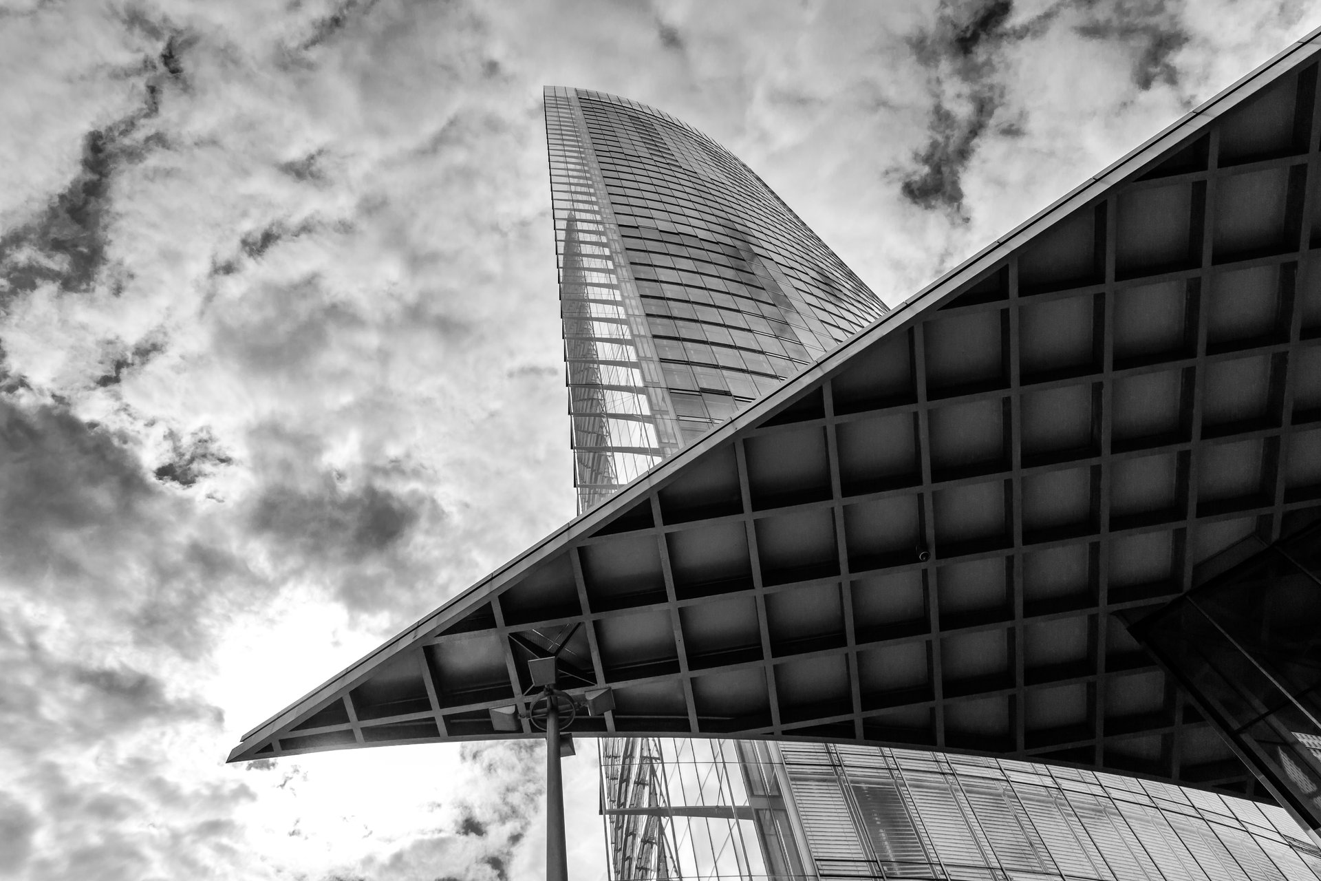 High-contrast architectural photograph of a skyscraper facade viewed from below