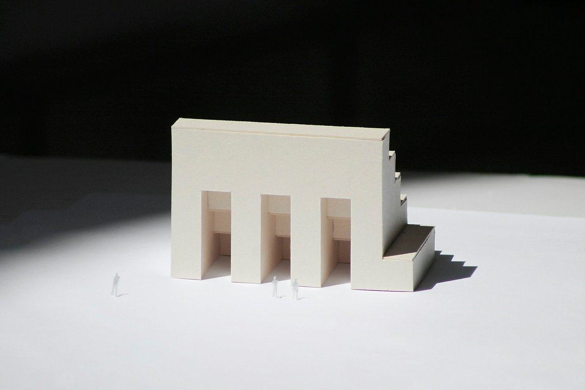 Architectural model in white basswood on a dark charcoal surface