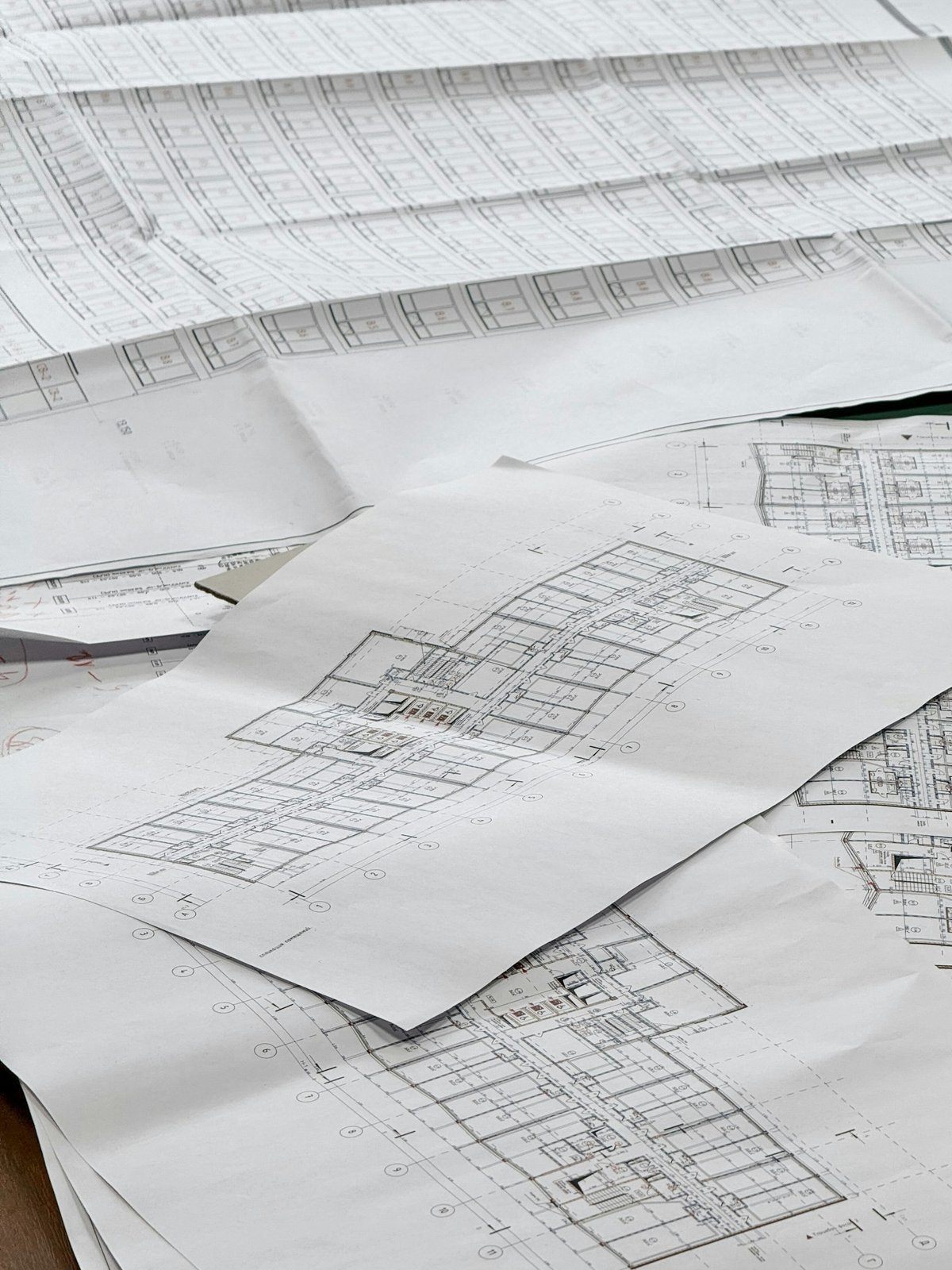Close-up of architectural blueprints and structural models on a conference table